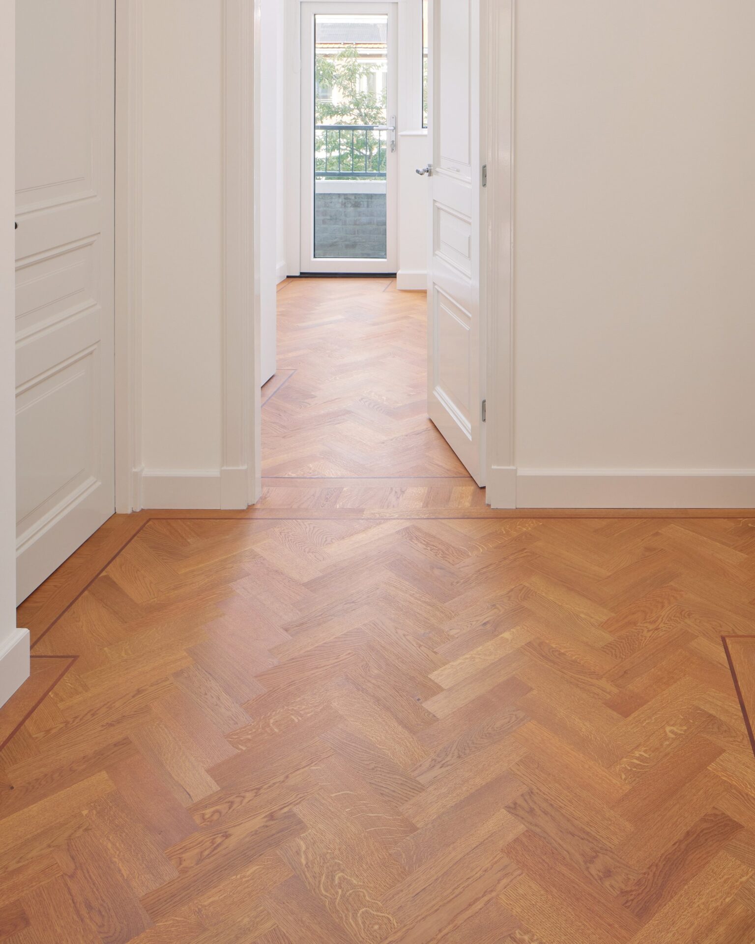 Traditioneel Tapis Parket De hal naar een kamer met een Traditioneel Tapis Parket gelegd door Riga houten vloeren uit Amsterdam